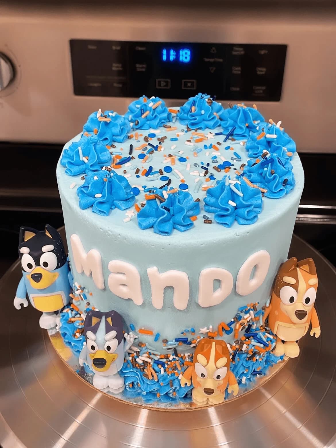 Custom Bluey themed birthday cake with blue frosting and character toppers
