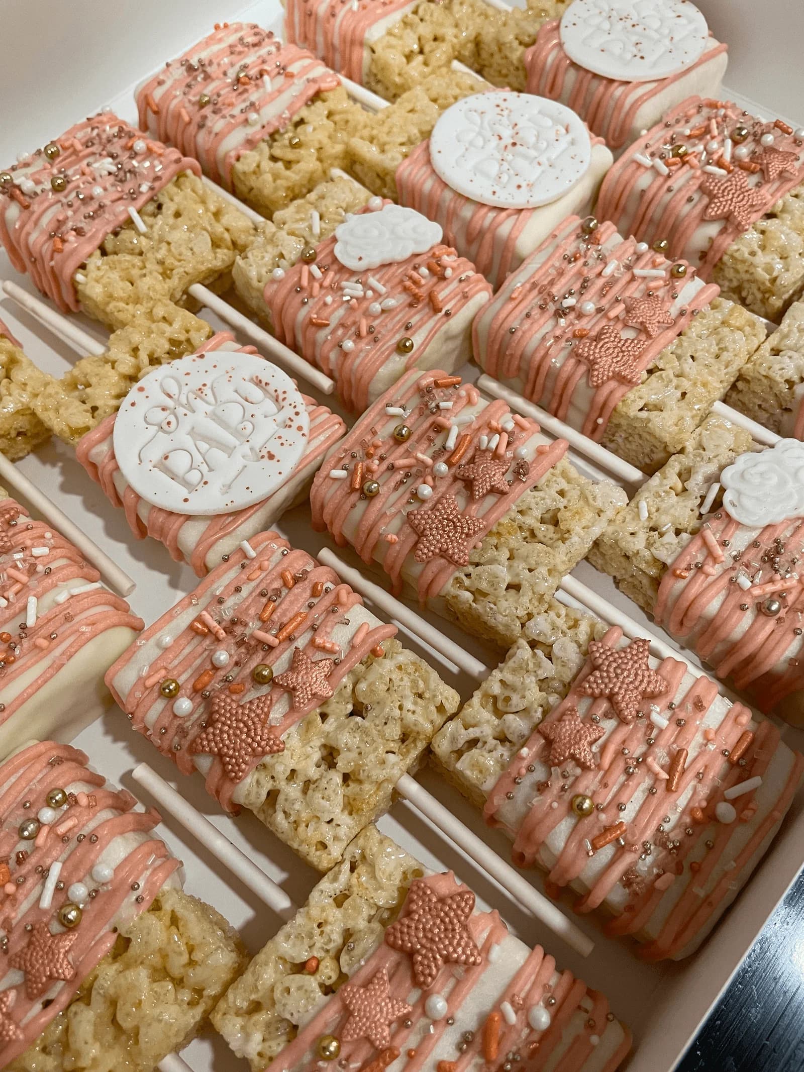 Baby shower Rice Krispie pops with pink drizzle and pearls