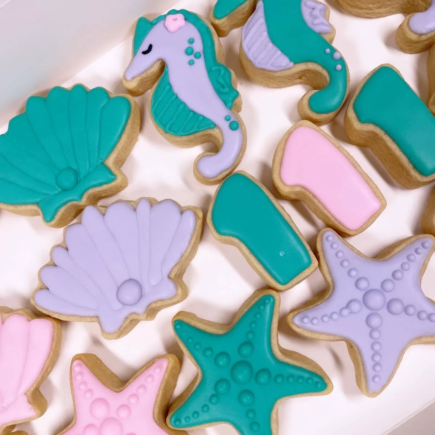 Mermaid themed decorated sugar cookies with seahorses, seashells, and starfish