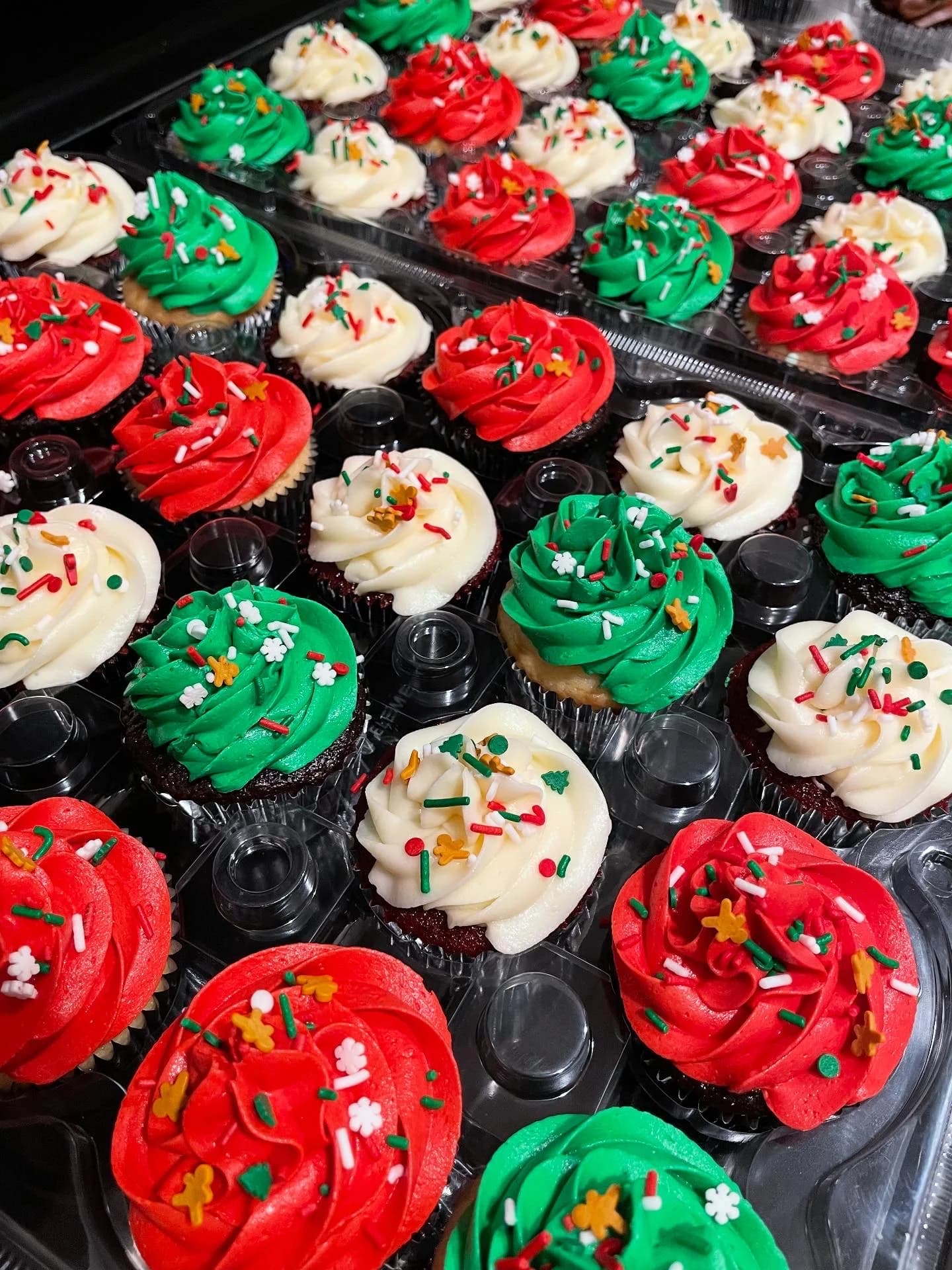Festive Christmas cupcakes with red, green, and white buttercream swirls and holiday sprinkles