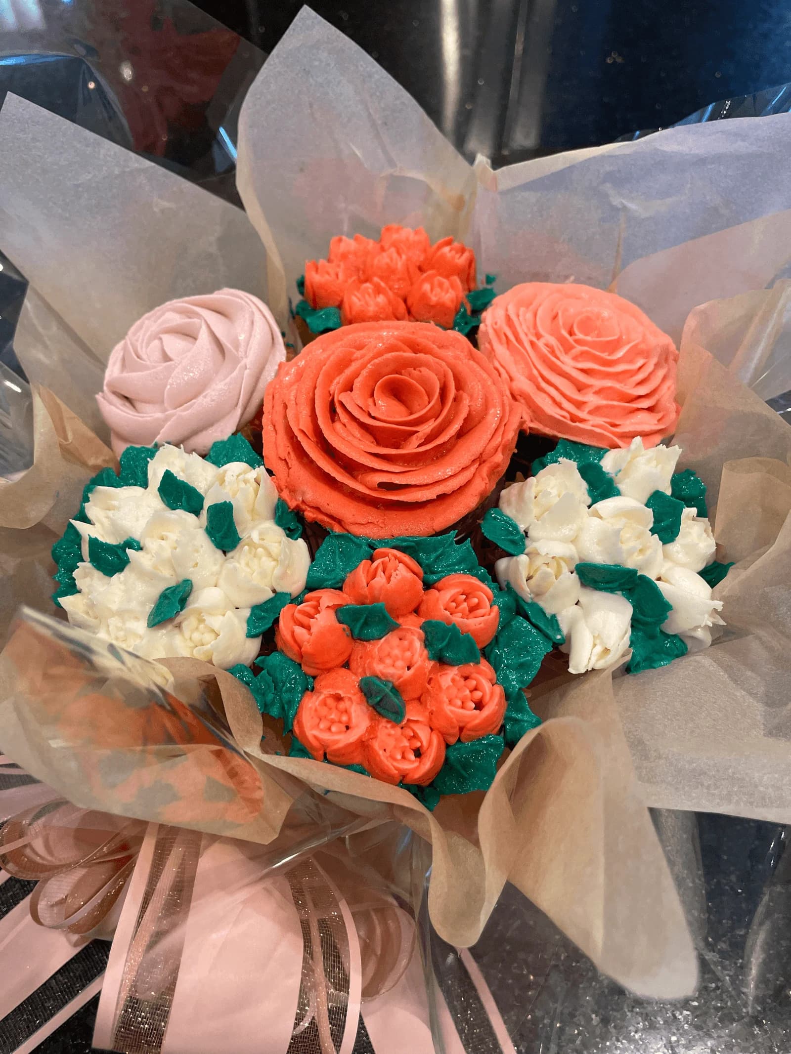 Elegant cupcake bouquet arrangement with coral and white roses